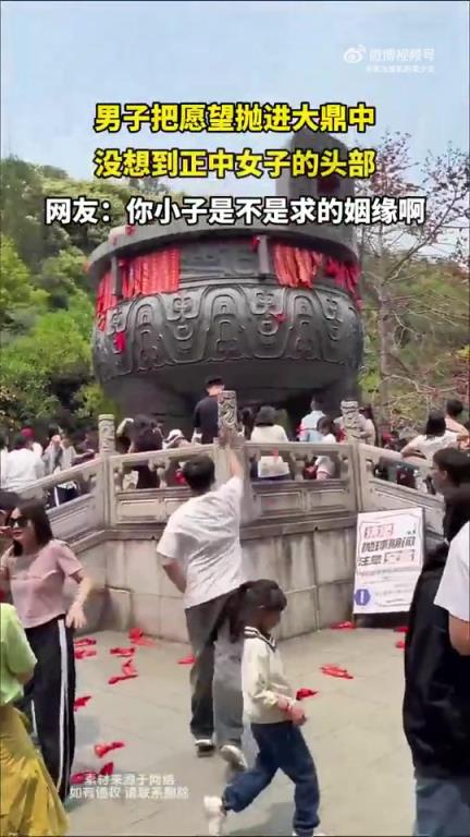 男子将愿望抛入大鼎,不料正中女子头部 男子将愿望抛入大鼎,不料正中女子头部