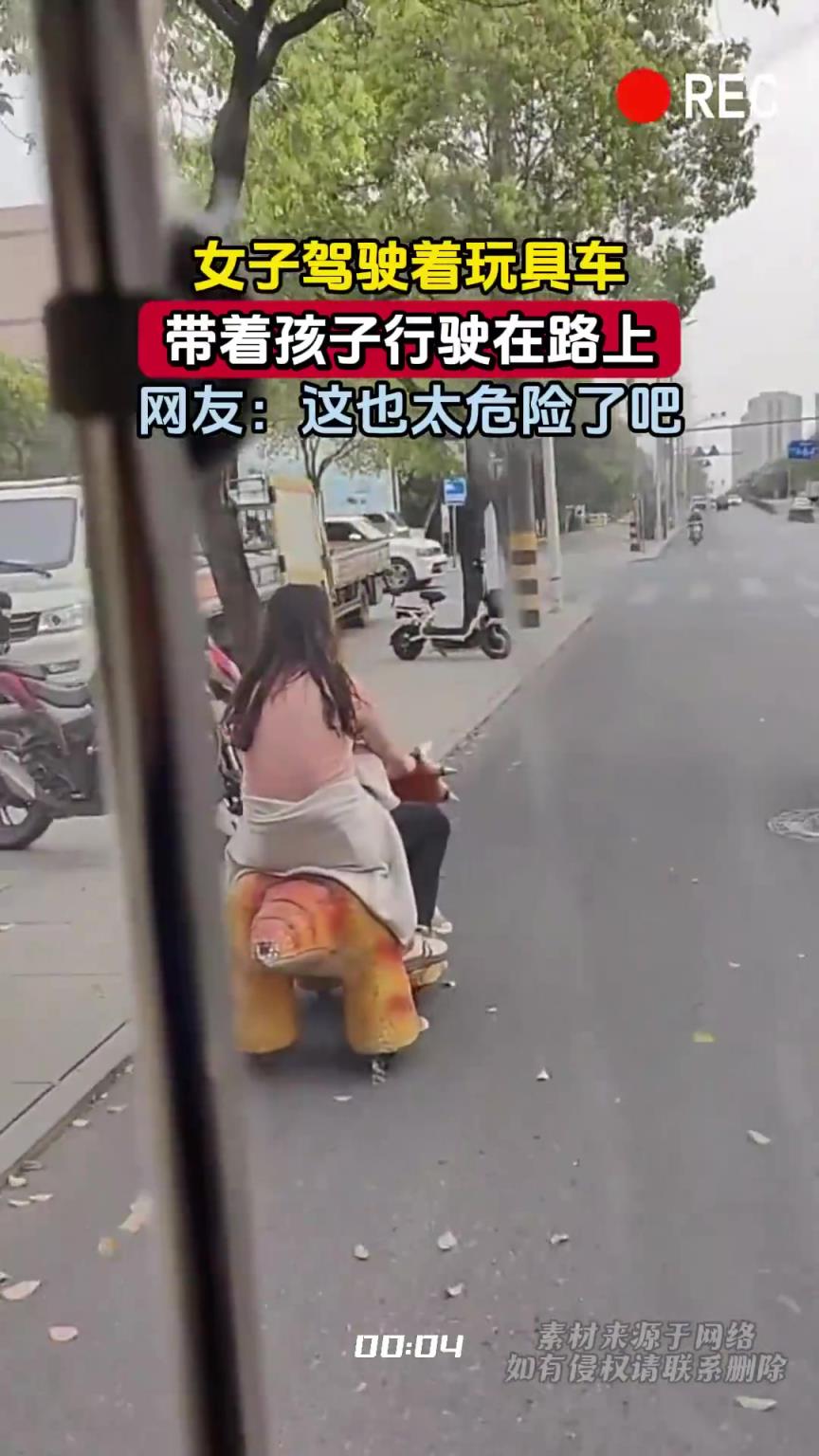 女子驾驶着玩具车,带着孩子行驶在路上 女子驾驶着玩具车,带着孩子行驶在路上