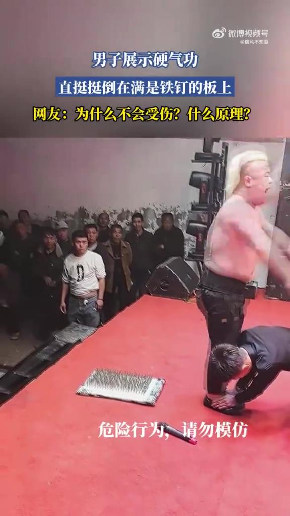 男子展示硬气功 直挺挺倒在满是铁钉的板上