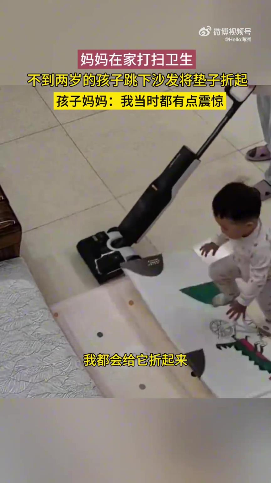 妈妈在家打扫卫生，不到两岁的孩子跳下沙发将垫子折起