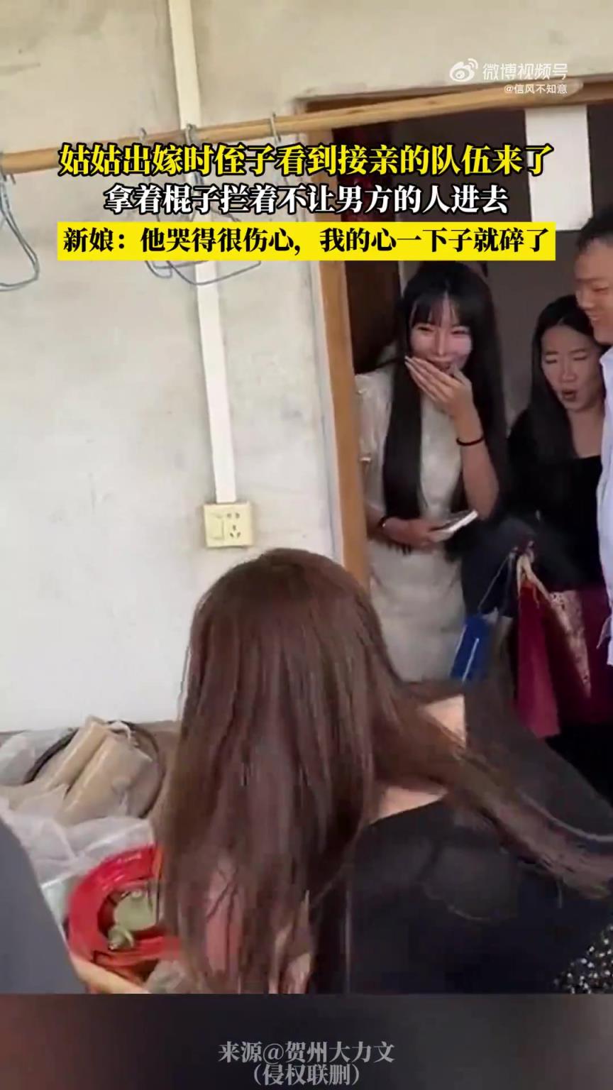 姑姑出嫁时侄子看到接亲的队伍来了，拿着棍子拦着不让男方的人