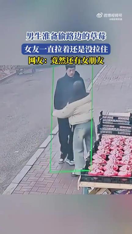 男生准备偷路边的草莓，女友一直拉着还是没拉住！