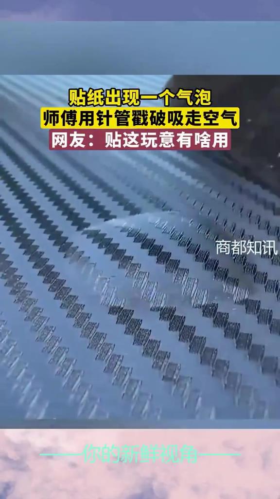 貼紙出現(xiàn)一個(gè)氣泡，師傅用針管戳破吸走空氣