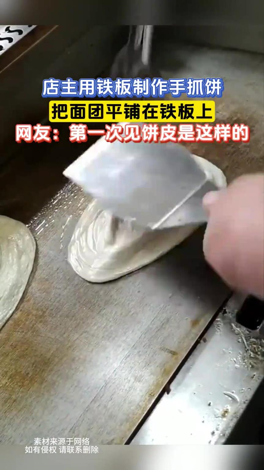 店主用鐵板制作手抓餅，把面團平鋪在鐵板上