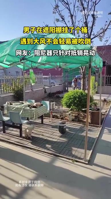 男子在遮阳棚挂桶，大风下不易被吹倒
