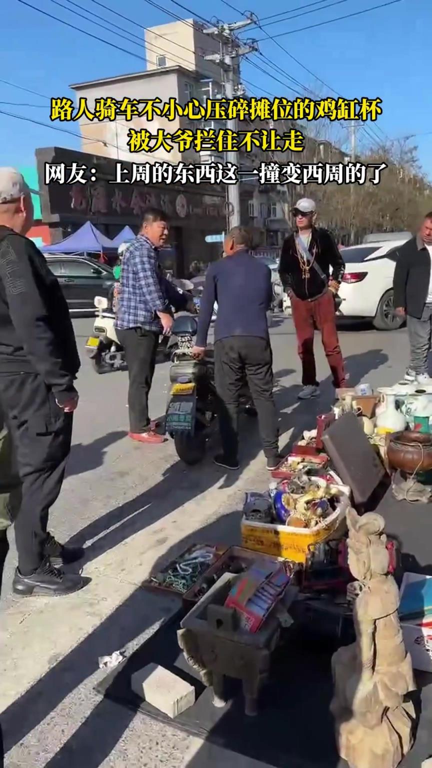 路人骑车不小心压碎摊位的鸡缸杯，被大爷拦住不让走