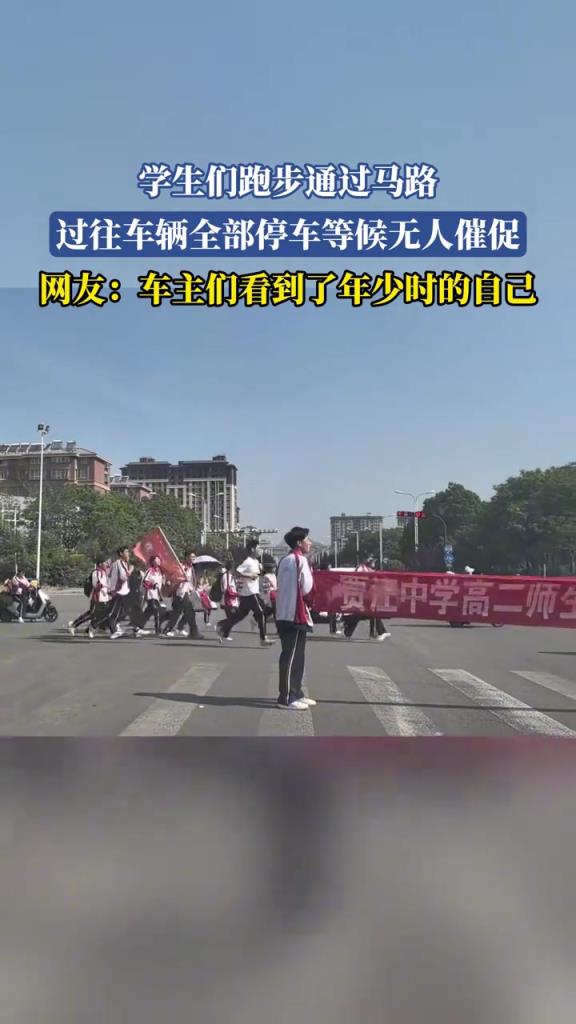 学生们跑步通过马路 过往车辆全部停车等候无人催促