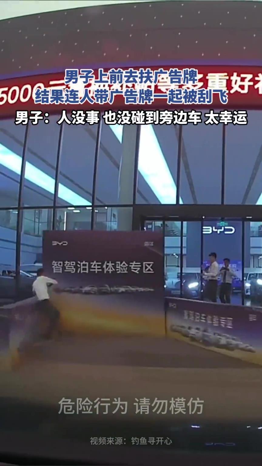 男子上前去扶廣告牌，結果連人帶廣告牌一起被刮飛！??！