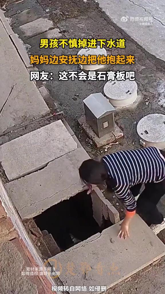 男孩不慎掉進(jìn)下水道，媽媽邊安撫邊把他抱起來