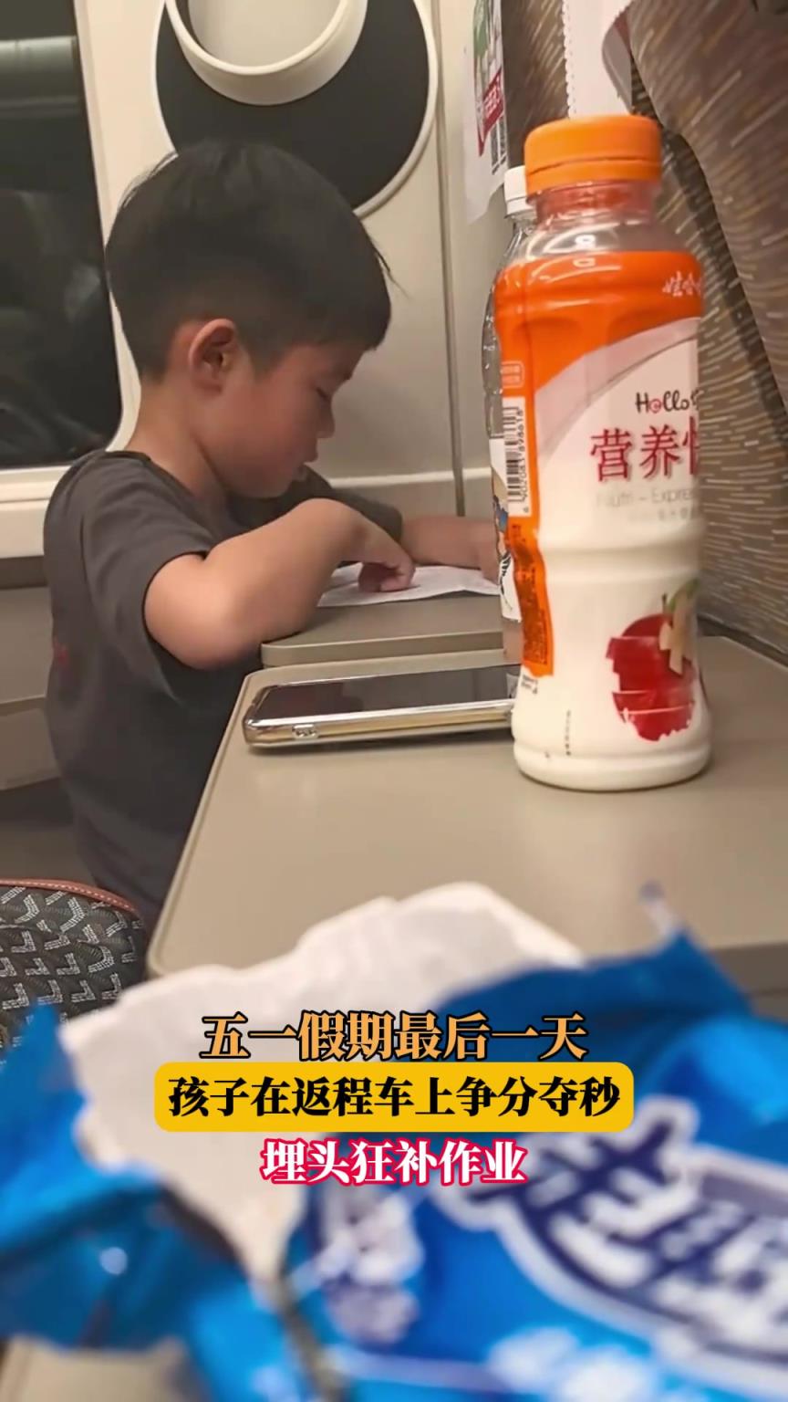 五一假期最后一天，孩子在返程車上爭分奪秒，埋頭狂補作業(yè)