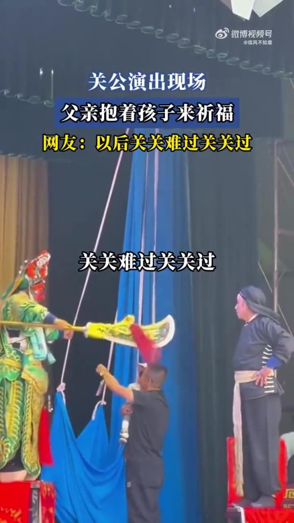 关公演出现场，父亲抱孩子祈福