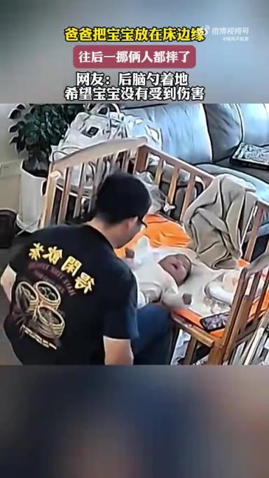 爸爸將寶寶放床邊緣，挪動(dòng)時(shí)父子倆不慎摔倒