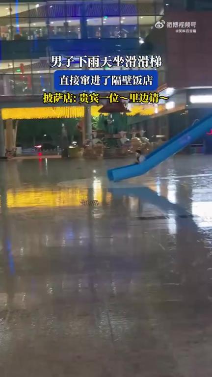 男子雨天坐滑滑梯沖進(jìn)隔壁披薩店，店家打趣迎貴賓