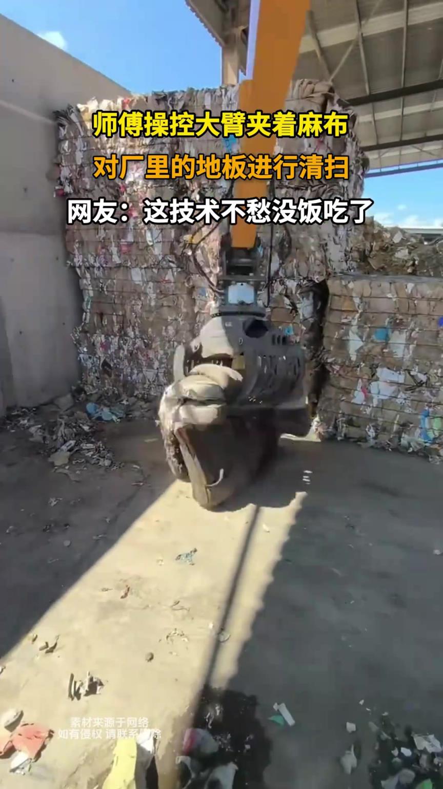 師傅操控大臂夾著麻布，對(duì)廠里的地板進(jìn)行清掃