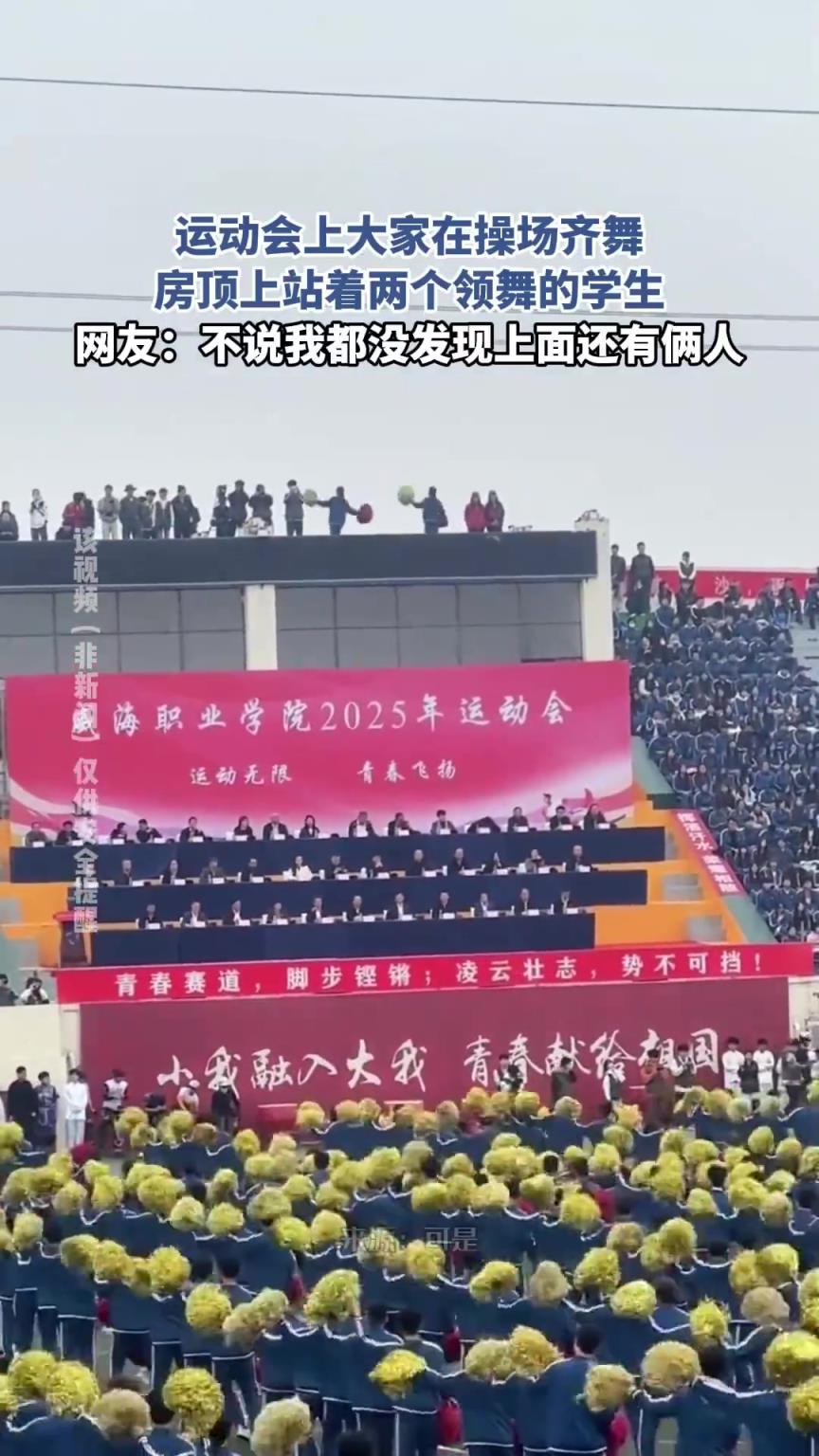 運(yùn)動(dòng)會(huì)上大家在操場(chǎng)齊舞，房頂上站著兩個(gè)領(lǐng)舞的學(xué)生??！