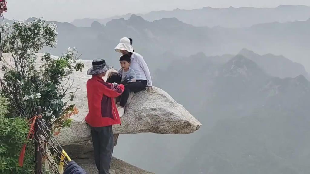 游客拍照打卡，拍攝者和大人，有繩索保護(hù)，小孩子沒有任何保護(hù)