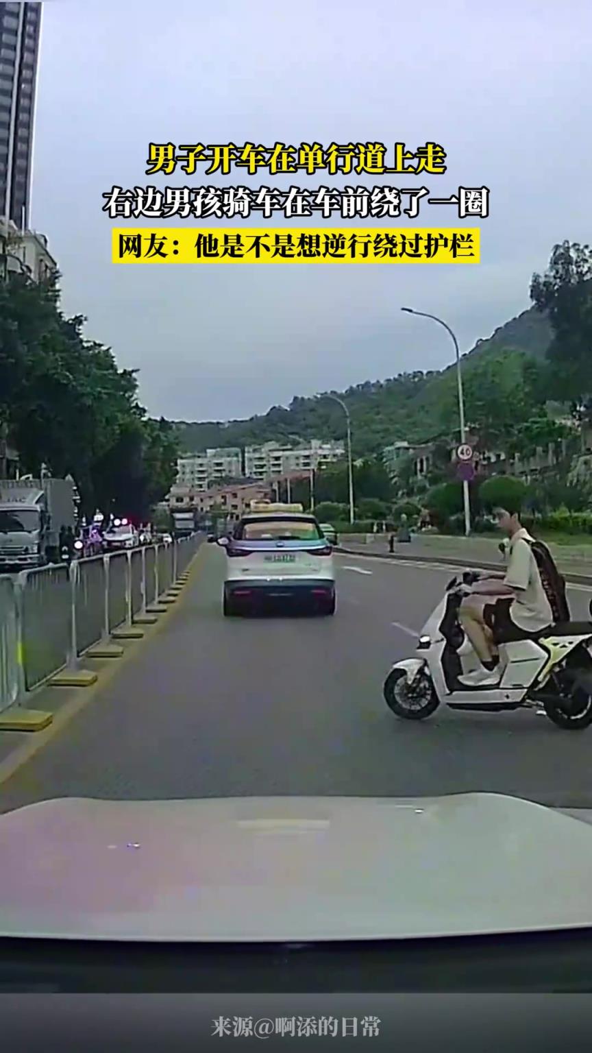 男子開車在單行道上走，右邊男孩騎車在車前繞了一圈