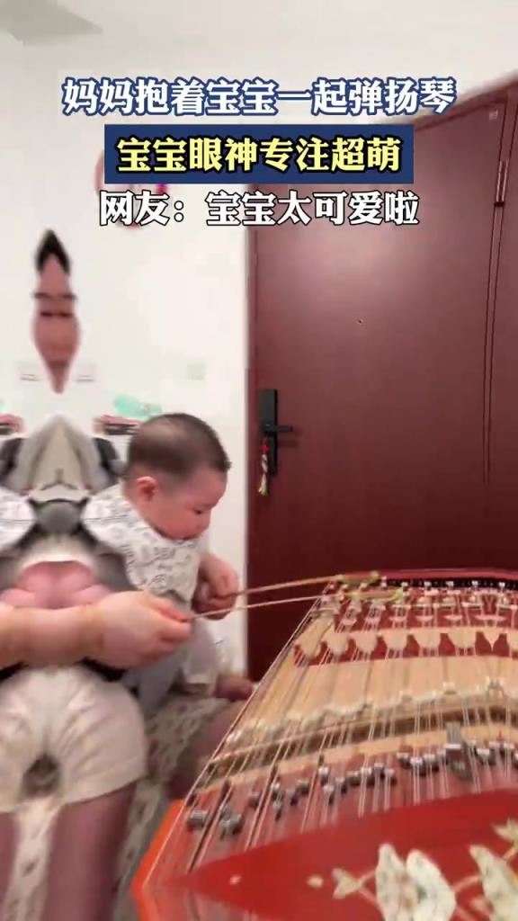 妈妈抱着宝宝一起弹扬琴，宝宝眼神专注超萌