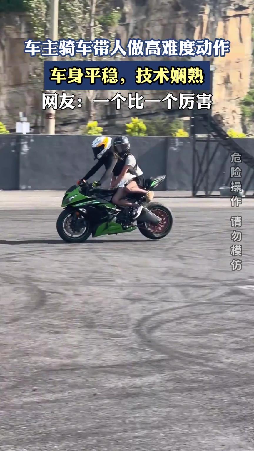 车主骑车带人做高难度动作，车身平稳，技术娴熟