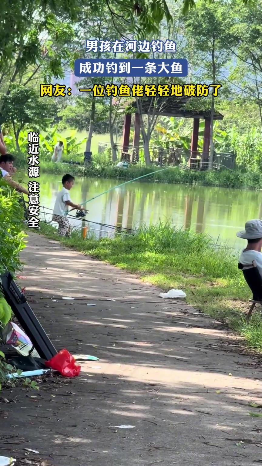 男孩在河邊釣魚，成功釣到一條大魚，一位釣魚佬輕輕地破防了