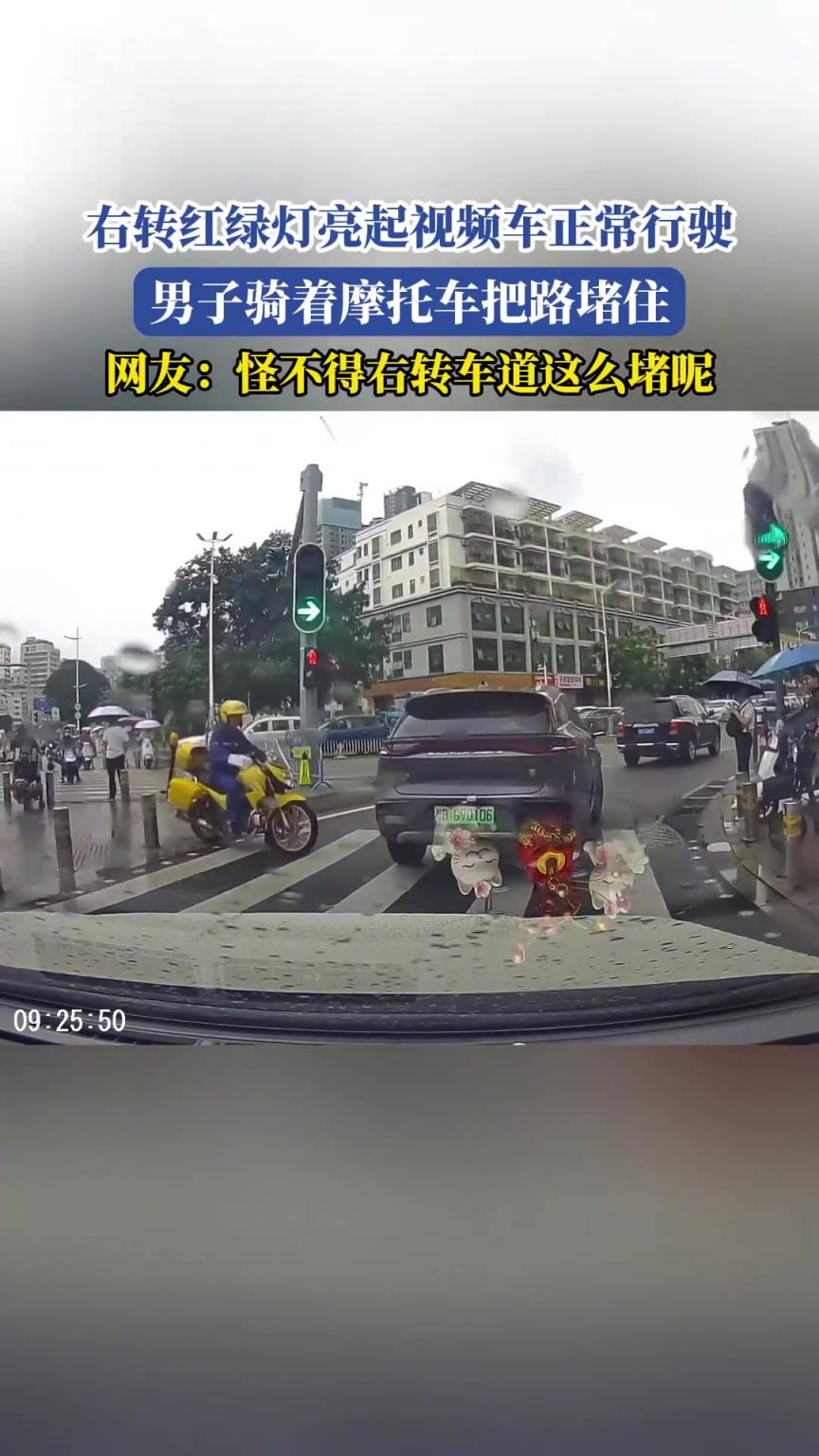右轉(zhuǎn)紅綠燈亮起視頻車正常行駛，男子騎著摩托車把路堵住